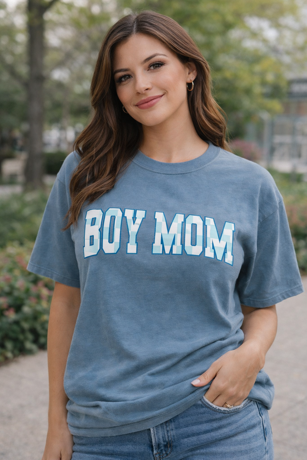 Woman wearing Boy Mom Comfort Colors t-shirt with blue checkered lettering outdoors