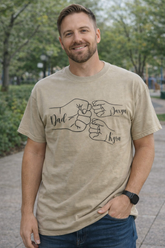 Father wearing personalized dad fist bump t-shirt with kids names in outdoor park setting