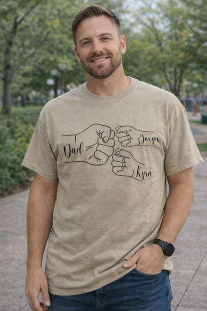 Father wearing personalized dad fist bump t-shirt with kids names in outdoor park setting