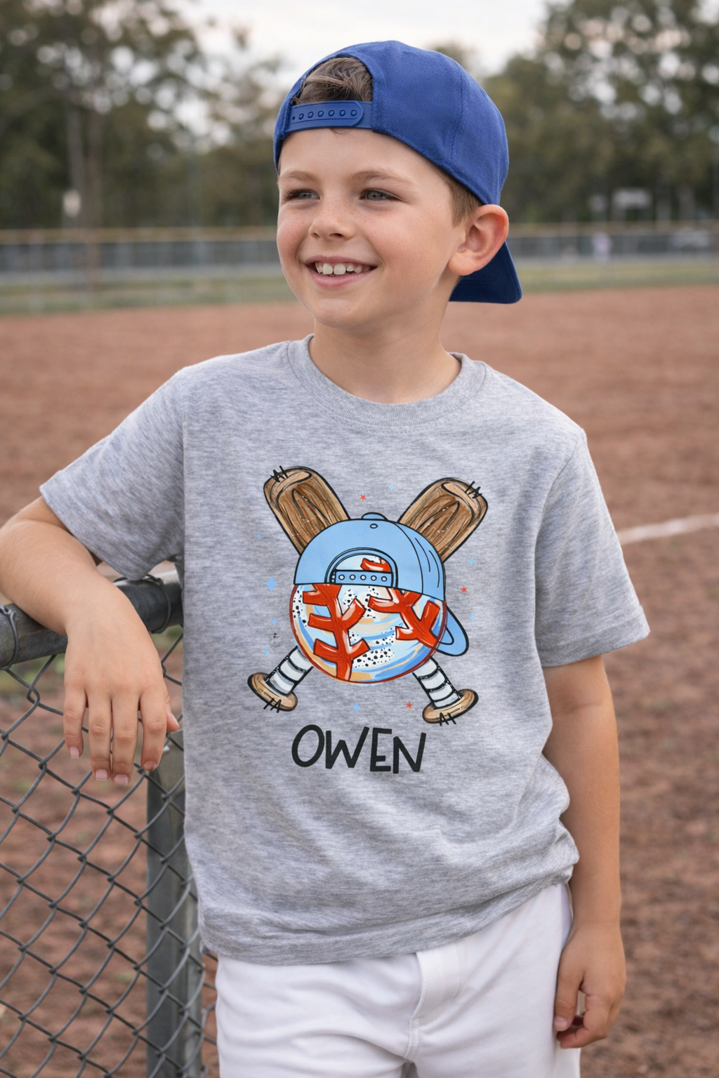 Young boy wearing personalized baseball shirt with custom name standing at a baseball field